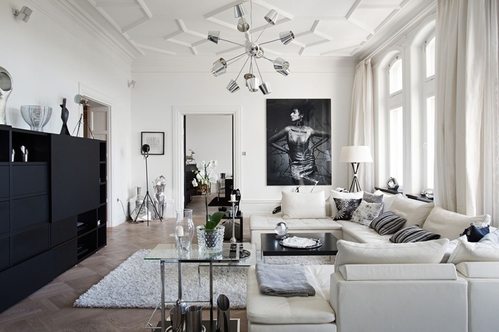 tableau noir et blanc décoration salon style épuré meuble noir mat sans poignée tapis moelleux blanc revêtement sol bois