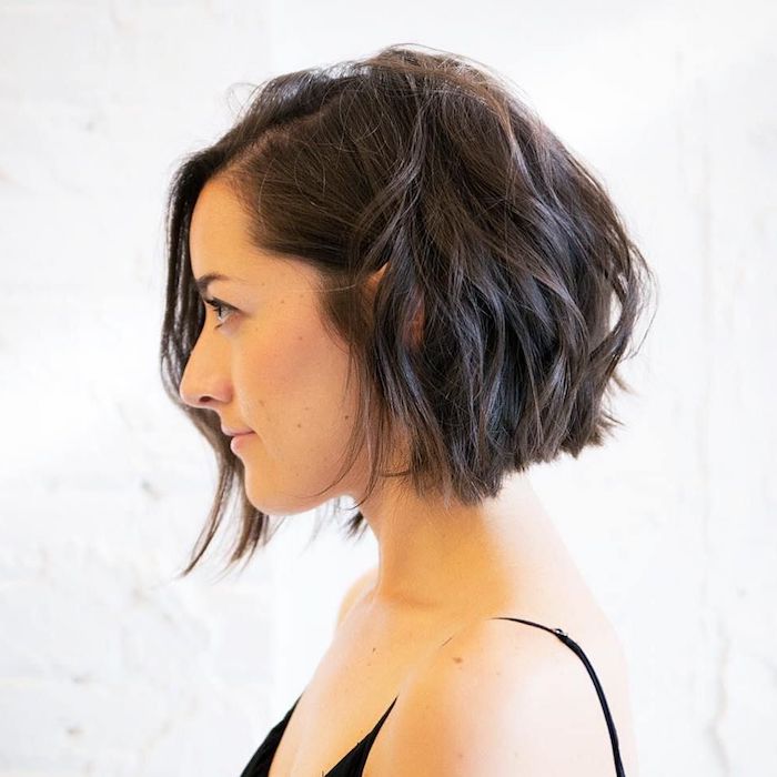 8 short hairstyles for fine hair for a young woman with black hair in waves and a black top