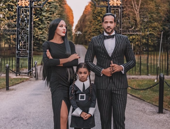 la famille addams deguisement trio devant une grande porte famille avec un chuen