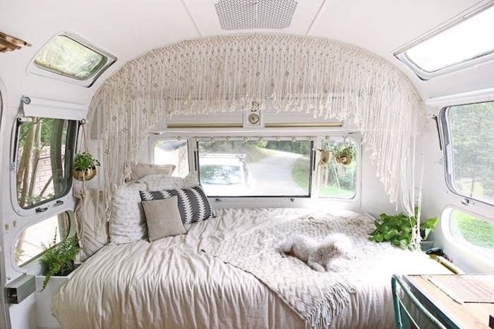 amenager son fourgon décoration bohème hippie chic jeté lit blanc coussins décoratifs rideaux macramé plantes vertes