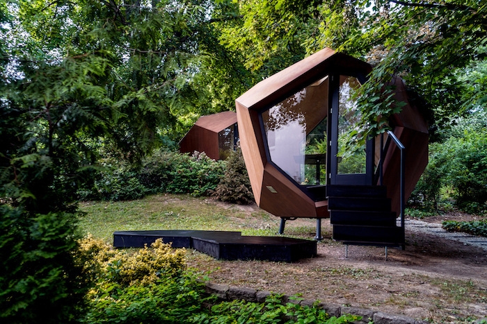 chalet en bois 20m2 devant maison avec une forme futuristique hexagonale edifice moderne