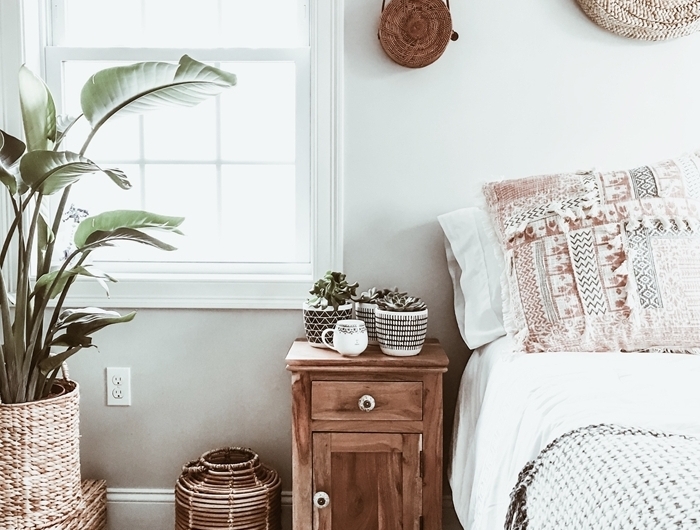 chambre style bohème meuble de chevet bois tapis blanc et noir franges cache pot tressé plantes vertes d intérieur