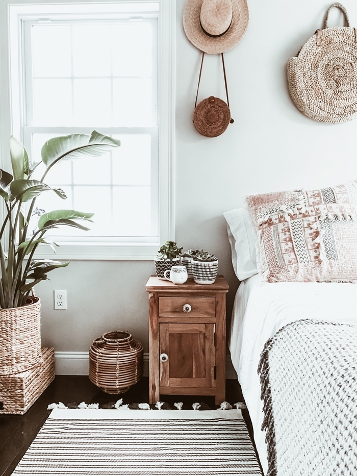 chambre style bohème meuble de chevet bois tapis blanc et noir franges cache pot tressé plantes vertes d intérieur