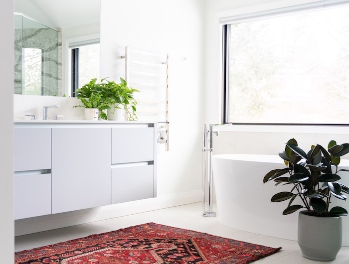 comment aménager une salle de bain cocooning blanche aux accents verts et tapis oriental coloré grand miroir rectangulaire