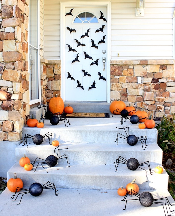 deco porte halloween araignées en papier de couleur noire des araignées et multitude de citrouilles et potimarrons de halloween