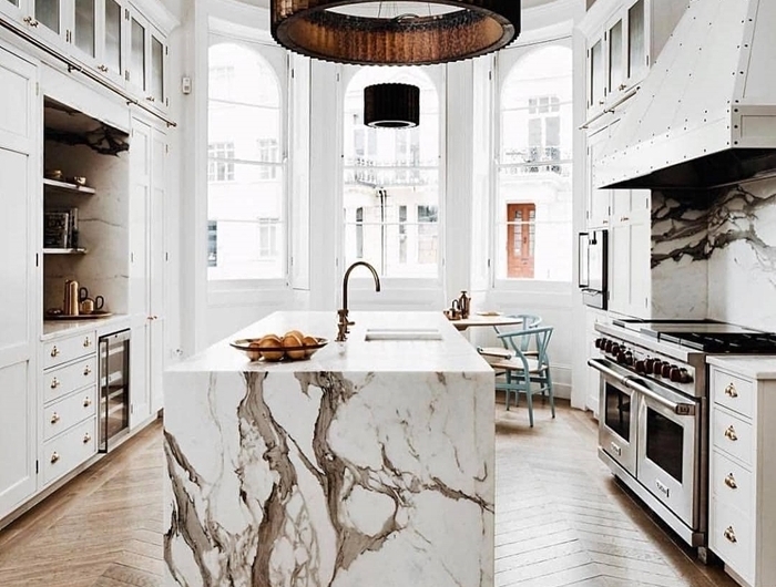 design intérieur agencement cuisine en parallèle avec îlot central cuisine blanche et marbre parquet bois accents métal rose gold