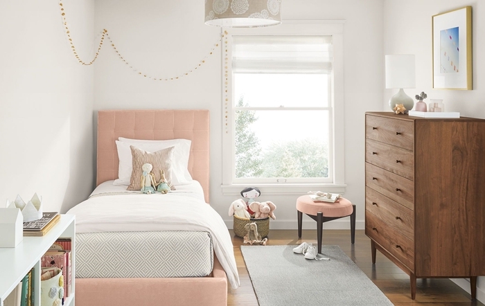 déco chambre blanche enfant lit avec tete de lit boutonnée en rose pastel meuble commode bois foncé revêtement de sol bois