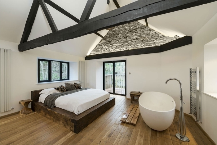 décoration chambre avec salle de bain ouverte parquet bois baignoire autoportante plafond blanc avec poutres bois noir