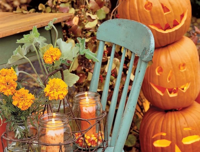 exemple de décoration halloween à fabriquer dans des bocaux en verre décorés de bonbons mais et bougie vase en pot et citrouilles jack o lantern superposées