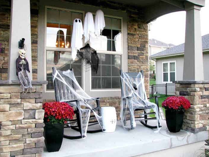 exemple terrasse avec deco halloween0diy exterieure chaises à bascule décorées de toiles d araingée pots avec fleurs d automne fantomes en balllon et toile blanche
