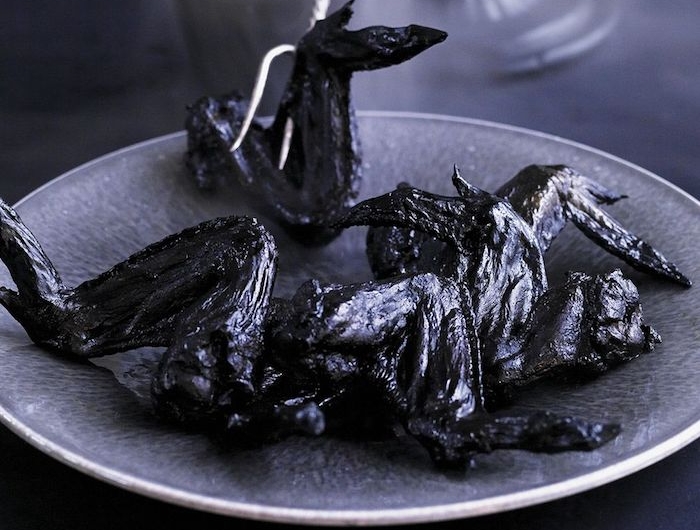 idee d entree de halloween des ailes de poulet aigers sucres colorees en noir plat effrayant