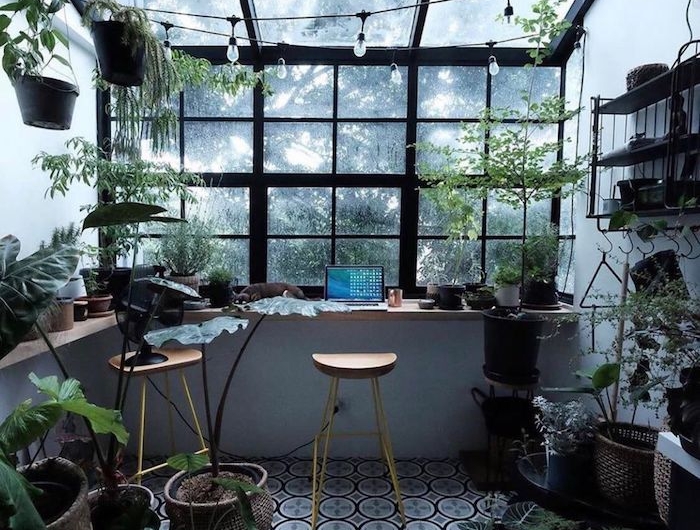 idee deco bureau dans le jardin abondance des plantes et pots deux chaises de bar un guirlande de petits lampes