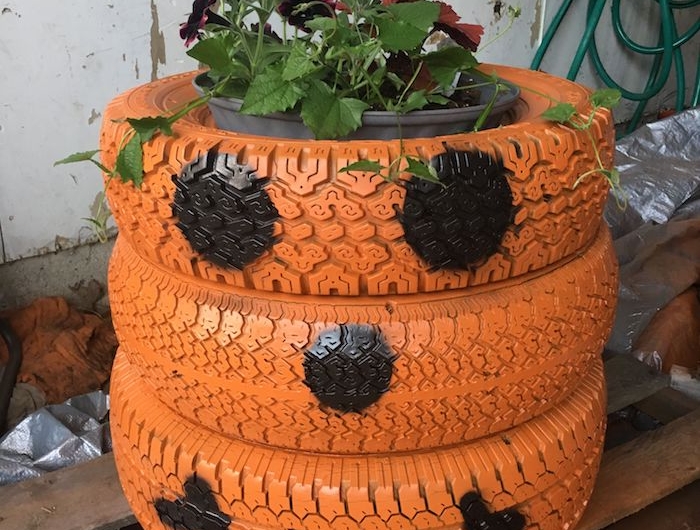 jardinière cachle pot en pneus recyclés motif citrouille jack o lantenr en peinture orange et noir
