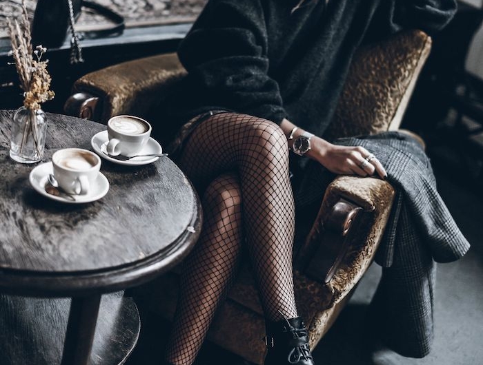 look vintage femme une fille assis dans un fauteuil portante des meches une tables avec deux tasses de cafe