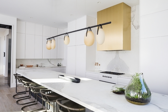 luminaire suspendu lampe design moderne or mat cuisine marbre blanc chaises de bar noire crédence marbre blanc