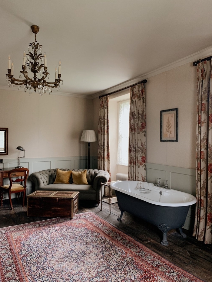 lustre tapis motifs ethniques canapé boutonné gris salle de bain suite parentale bureau bois foncé chaise rideaux motifs floraux