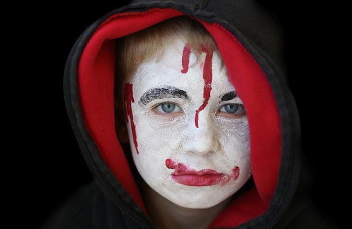 maquillage effrayant de halloween pour un enfant comme vampire avec capuche rouge