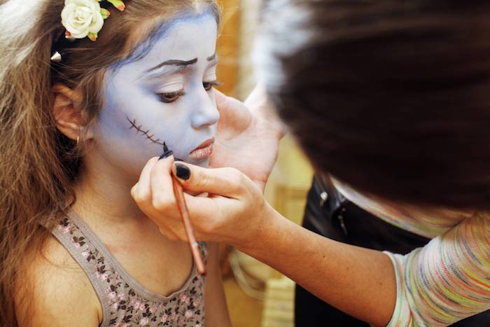 maquillage halloween fille visage peint en bleu avec des engrenures chez le maquilleur