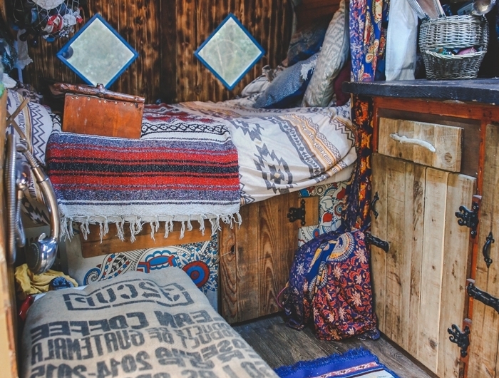 objets textiles motifs ethniques guirlande lumineuse plafond bois fourgon aménagé interieur plaid coussins déco bohème