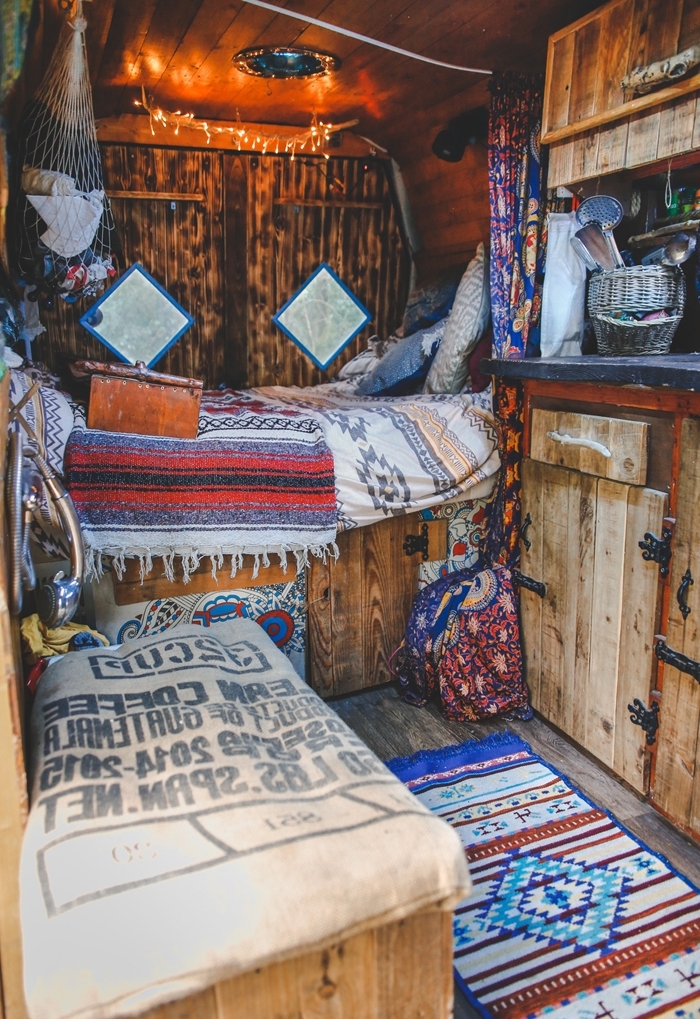 objets textiles motifs ethniques guirlande lumineuse plafond bois fourgon aménagé interieur plaid coussins déco bohème