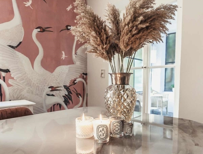 papier peint terracotta motifs cigogne plante plumeau table marbre bougies vase verre déco salle à manger moderne