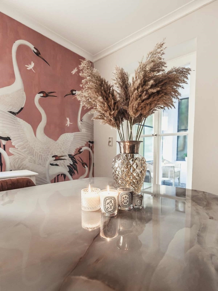 papier peint terracotta motifs cigogne plante plumeau table marbre bougies vase verre déco salle à manger moderne