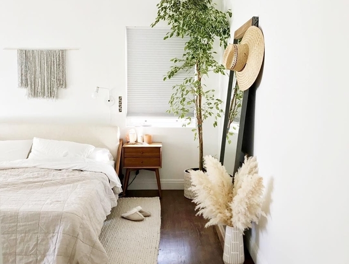 plante chambre à coucher meuble de chevet bois parquet bois foncé tapis blanc macramé suspension fleur de pampa deco
