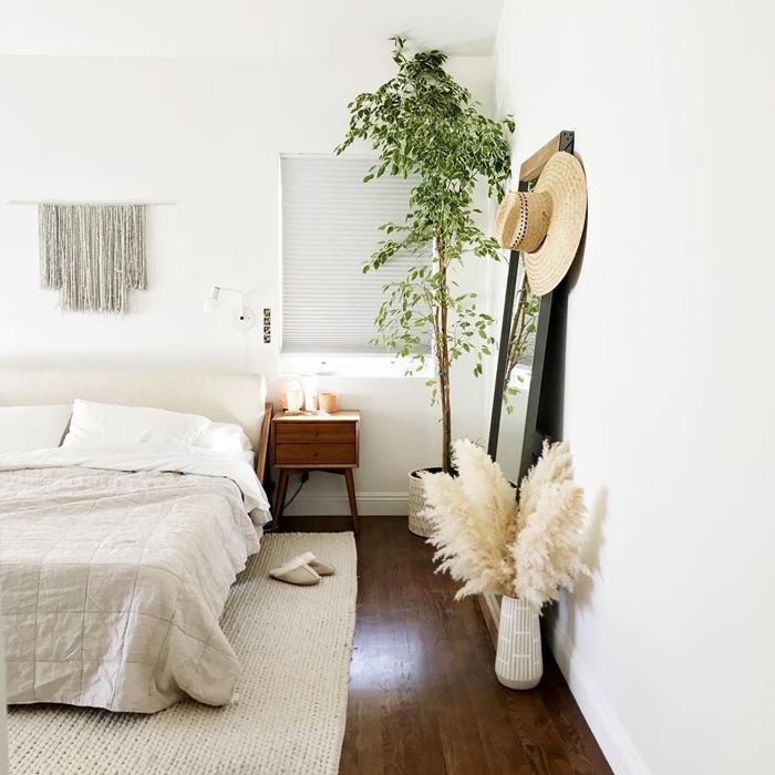 plante chambre à coucher meuble de chevet bois parquet bois foncé tapis blanc macramé suspension fleur de pampa deco