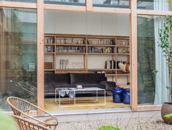 studio de jardin habitable precede de gravier avec grandes fenetres et une biblioteque deux chiases ratin