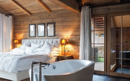 suite parentale salle de bain déco chalet chambre rustique revêtement de plafond poutres apparentes bois baignoire blanche autoportante