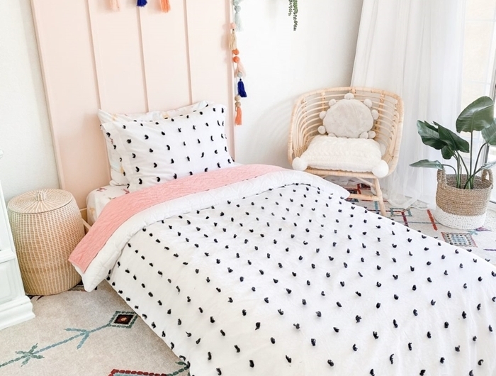 tapis blanc motifs géométriques colorés couverture de lit blanche motifs noirs deco tete de lit en bois peinture rose pastel guirlande glands diy