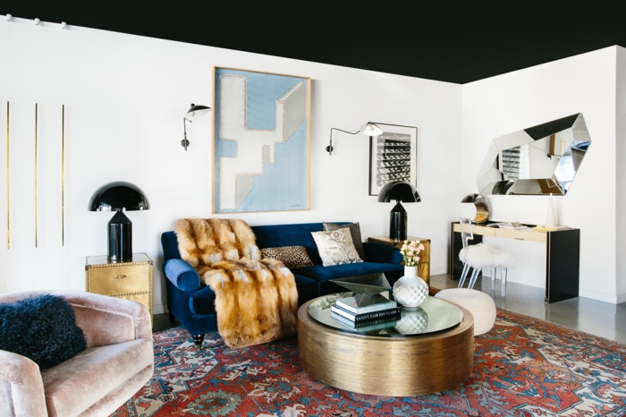 unique maison canapé bleu sombre table basse ronde dorée cocooning idee deco salon couleur de peinture pour salon moderne