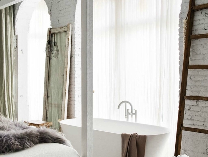 échelle décorative bois tabouret baignoire dans chambre décoration mur briques blanches cadre de lit bois blanc plaid fausse fourrure grise
