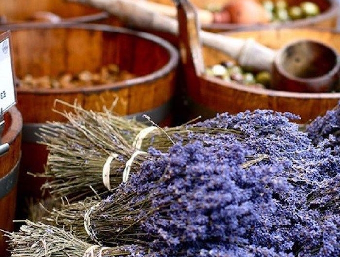 birn de lavande poses sur une table avec des tonnneau en bois pleins d olives
