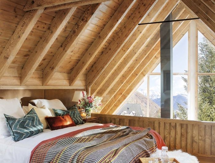 chambre sous comble mansardée deco rustique avec des couvertures chades bout de lit couvert de peau de mouton parquet bois clair
