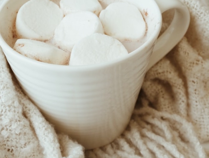 chocolat chaud blanc aux guimauves dans tasse blanche et couverture douillette idée boisson noel