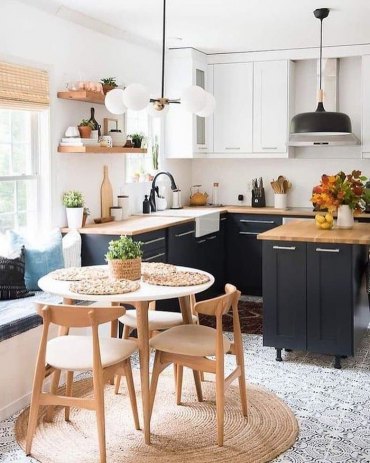 coin repas integre avec deux chaises et une table en bois a cote de deux grandes fenetres qui donnent vers la cour