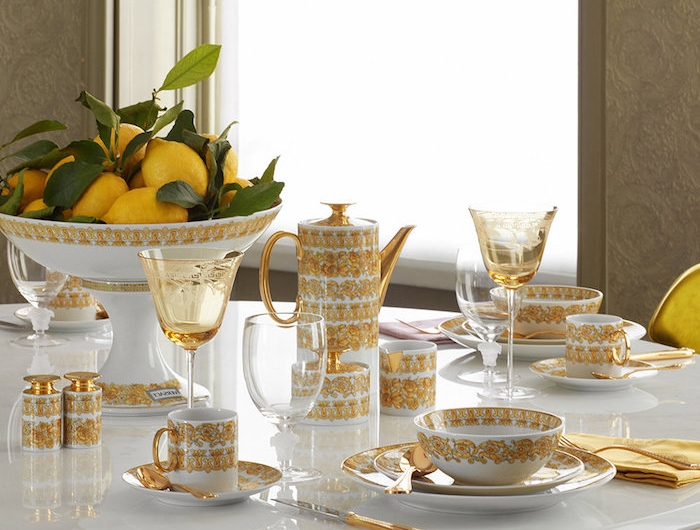 comment dresser une table avec des assiettes en porcelaine ornes des elements en or et un bol plein de citrons avec des nappes jaunes