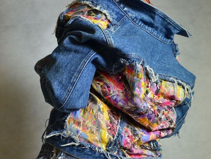 customise un jean avec des materiaux et tissus differents une mannequine avec des cheveux courts et un veste epaule nu