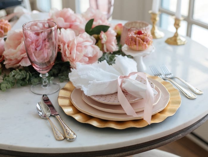 deco de table pour une marriage avec des fleurs roses des rubans et serviette blanc