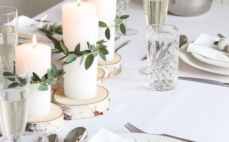 deco table anniversaire avec des branches vertes et fleurs dans assiette verres de champagne et d eaux cristaux