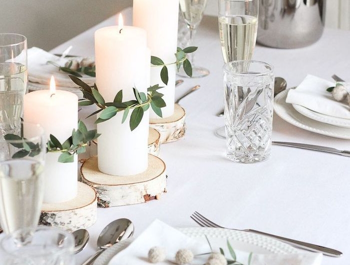 deco table anniversaire avec des branches vertes et fleurs dans assiette verres de champagne et d eaux cristaux