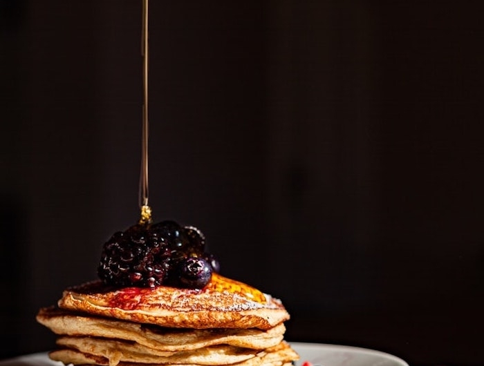 des crepes avec du sirop aux myrtilles dans une assiette esthetique allechante de fond d ecran