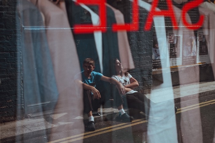 deux gens devant la vitrine d un magasin qui offre des rabais affaire de black friday