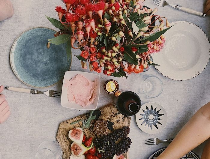 dresser une table a la francaise avec des assiettes multicolores et un plateau avec frommages fruits et pain
