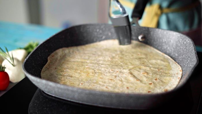 enduire une tortilla de beurre pour faire quesadilla maison exemple de recette mexicaine repas de midi facile