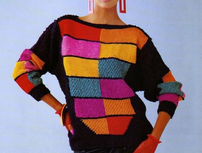 femme des années 80 dans un pull multicolore et jupe en cuire cheveux bouffes et boucles d oreilles enormes halloween inspo