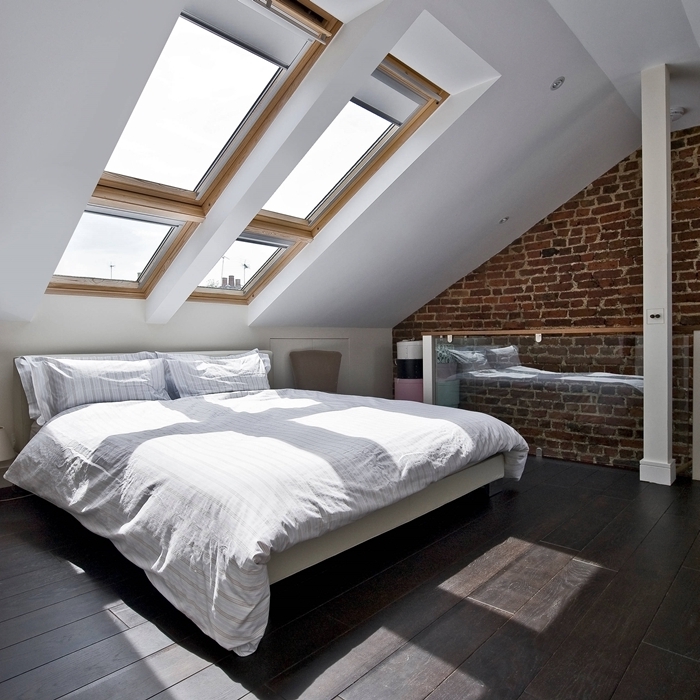fenêtre de plafond bois chambre sous les toits mur briques riuges design minimaliste lit cadre noir et blanc