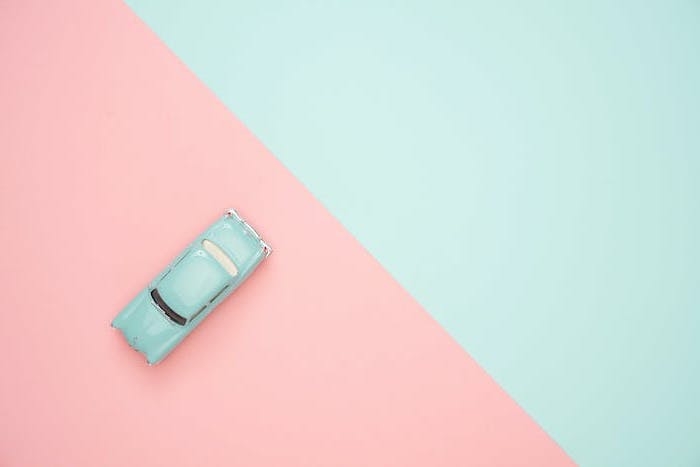 fond d ecran pastel divise en deux parties rose et bleue avec une jouette voiture