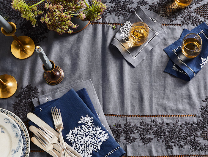 idee deco table noel avec des couvertes argentines nappe bleu avec des broderies assiettes en porcelaine